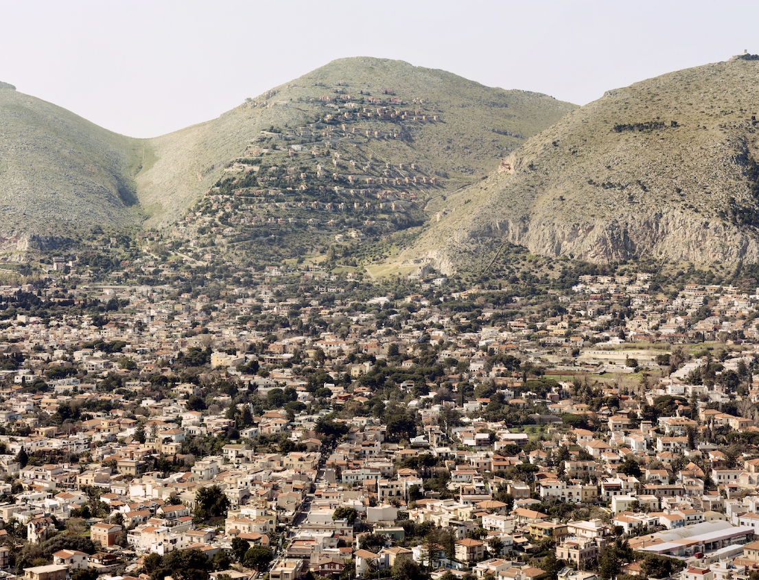 Collina di Pizzo Sella, Palermo, 2012. Nota come “la collina del disonore”, negli anni Settanta una ditta di costruzioni vicina alla famiglia del boss Michele Greco ha ottenuto le concessioni per costruire su Pizzo Sella circa 170 villette, che una sentenza del 2001 ha giudicato abusive e ne ha ordinato la confisca. Nell'aprile 2012 la Corte di Cassazione ha revocato la confisca, giudicando che all'epoca gli acquirenti avrebbero agito in buona fede, e quindi considerandoli non punibili con il sequestro delle abitazioni.