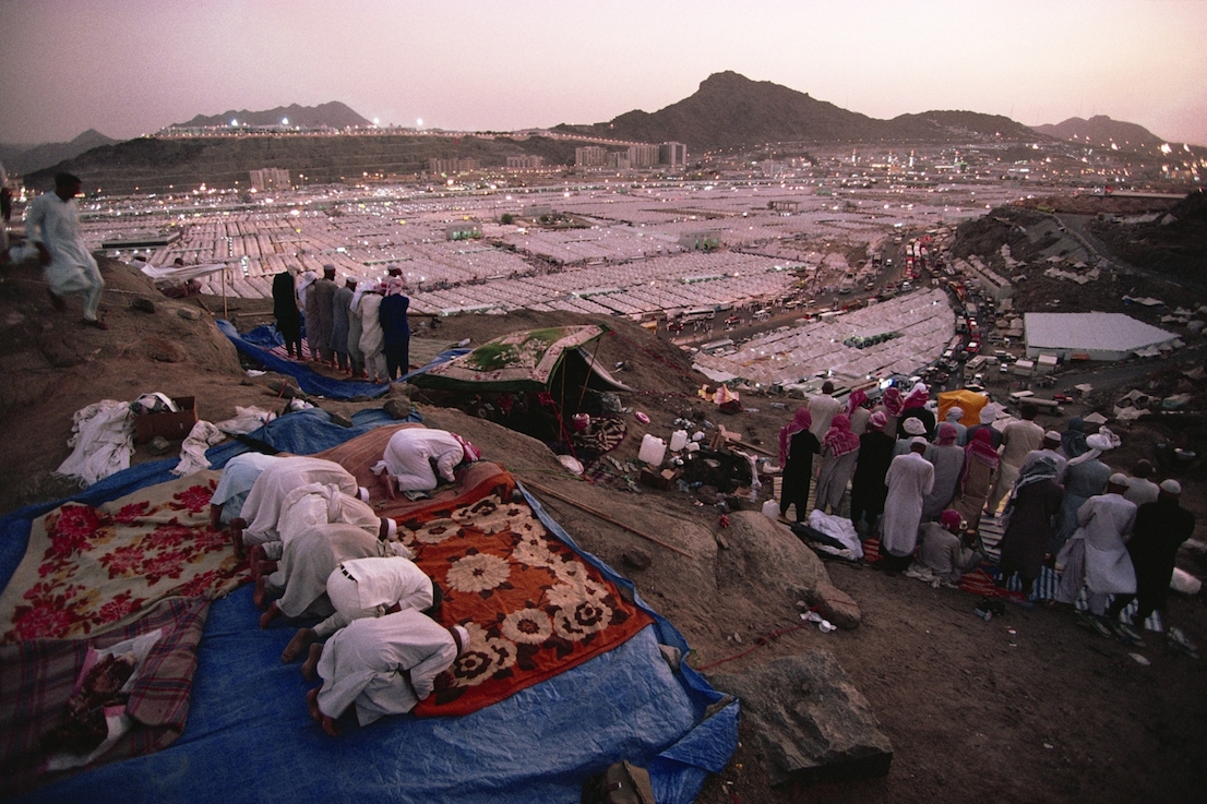 Foto di Kazuyoshi Nomachi. I pellegrini recitano il Maghrib dopo il tramonto nella tendopoli di Mina, allestita per accoglierli durante l’Hajj. La Mecca, Arabia Saudita 1995.