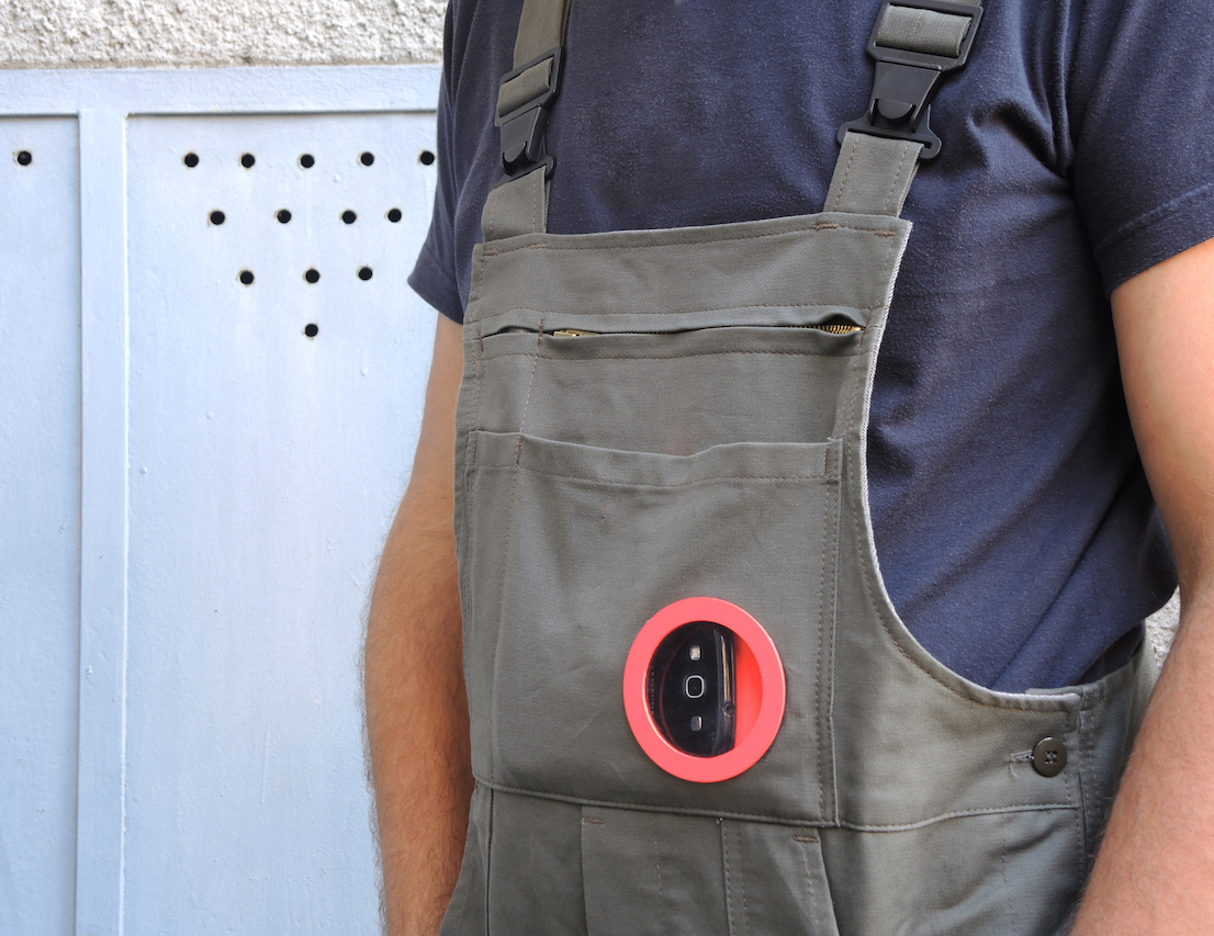 Shield and Share: connected protections for workers, design di Odo Fioravanti per TIM (TIM4Expo), 2015. Salopette da lavoro con oblò nella tasca frontale per posizionare il cellulare e riprendere il proprio lavoro in soggettiva.