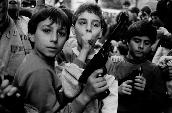 Letizia Battaglia, Festa del giorno dei morti. I bambini giocano con le armi. Palermo – 1986. Courtesy: Letizia Battaglia.