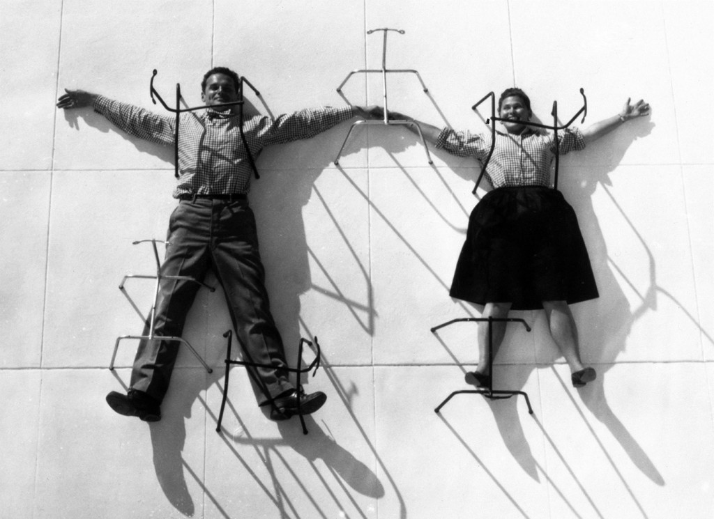 Charles and Ray Eames posing with chair bases. © Eames Office LLC.