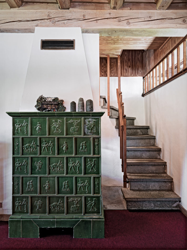 Thun stove clad in ceramic tiles on the ground floor and the stone staircase that leads to the second floor. Photo: © Marcello Mariana.